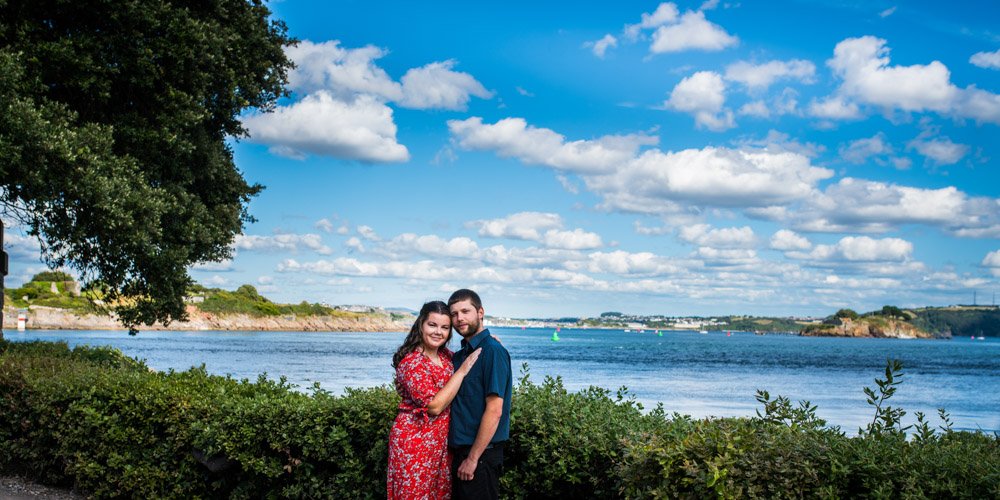 couple embracing in the woods by the sea at Mt Edgcumbe Park