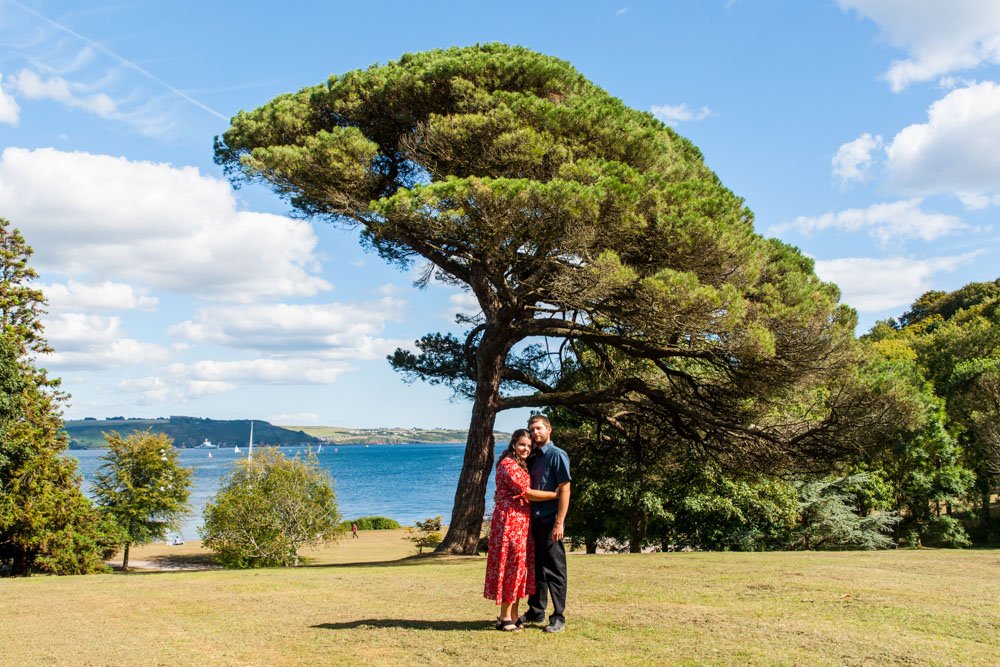 couple embracing in the woods by the sea at Mt Edgcumbe Park