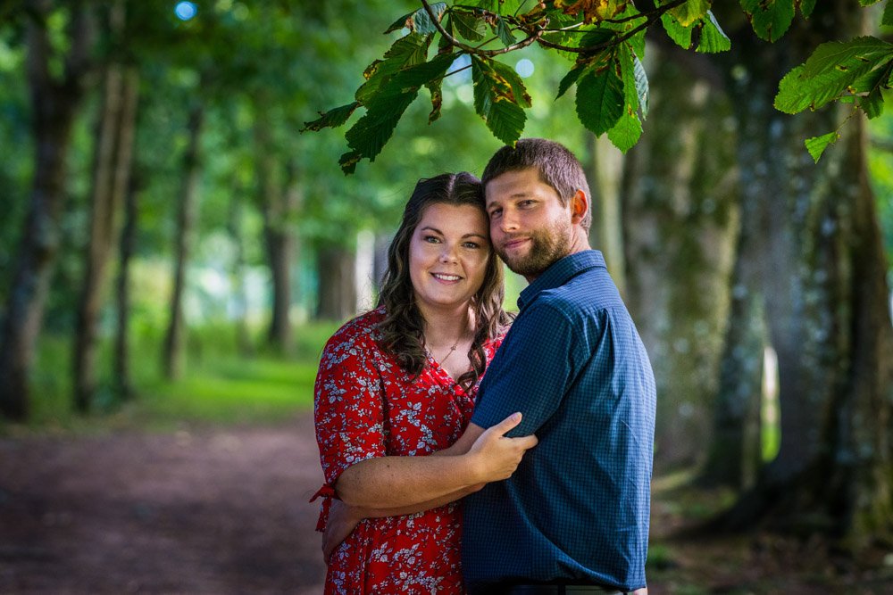 couple embrace in the woods at Mt Edgcumbe Park