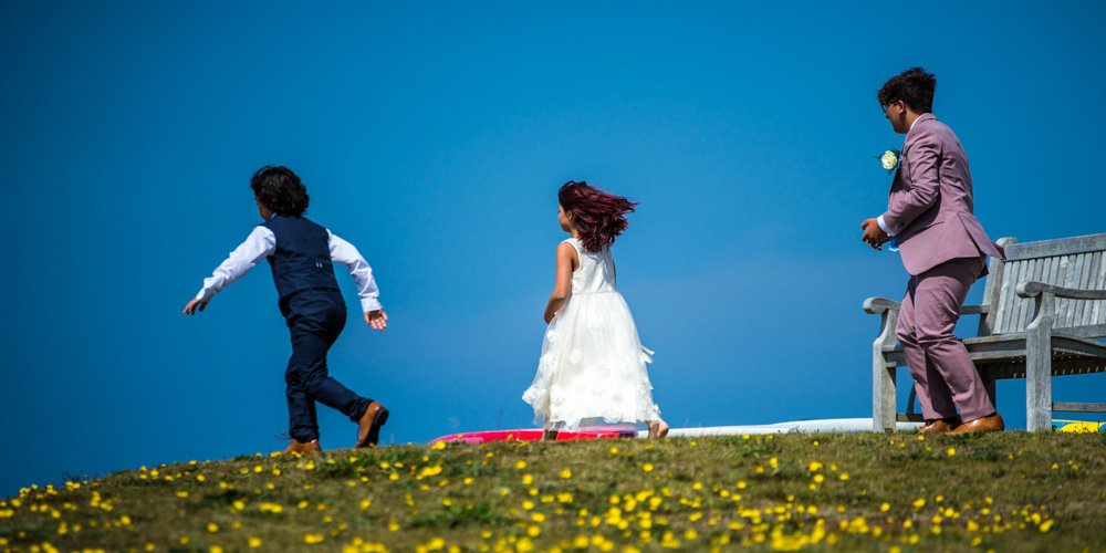 wedding guests on the fistral headland in Newquay