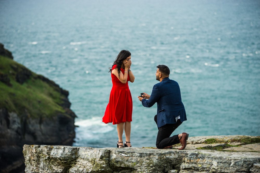 wedding proposal on a rock overlooking Tintagel castle cornwall