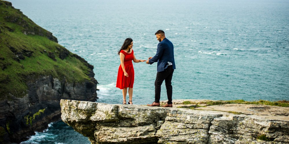 wedding proposal on a rock overlooking Tintagel castle cornwall