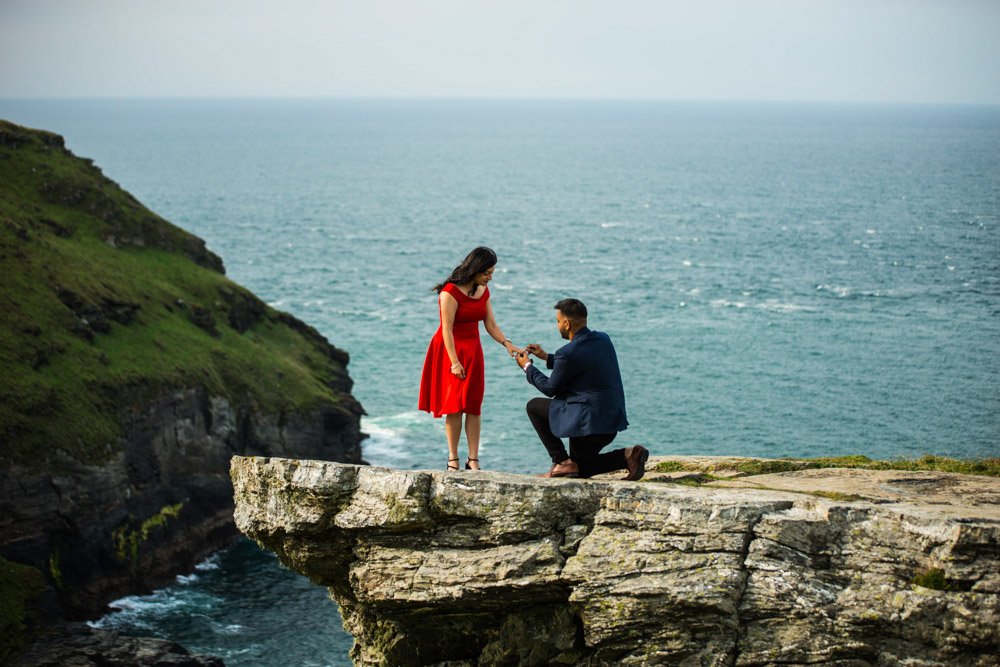wedding proposal on a rock overlooking Tintagel castle cornwall