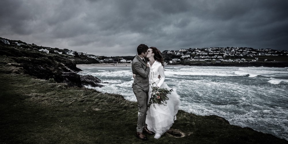 bride and groom kissing at stormy Polzeath cornwall modern antique