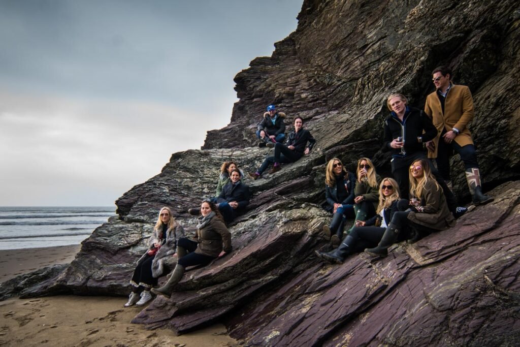 Ollie Locke and friends sitting on a rock at Polzeath Beach