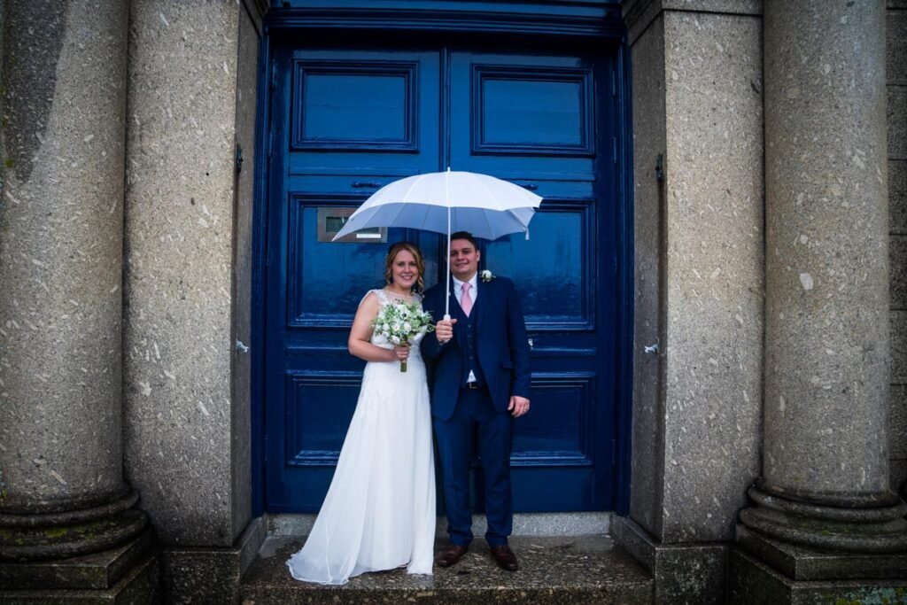 bride and groom with umbrella at penzance cornwall