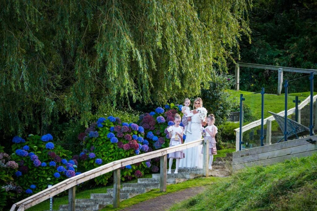 Bride and flower girls coming down the aisle at The Sandy Cove Hotel Devon