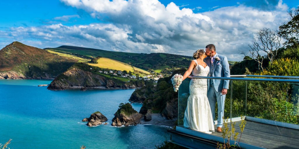 Bride and groom on the platform kissing at The Sandy Cove Hotel Devon
