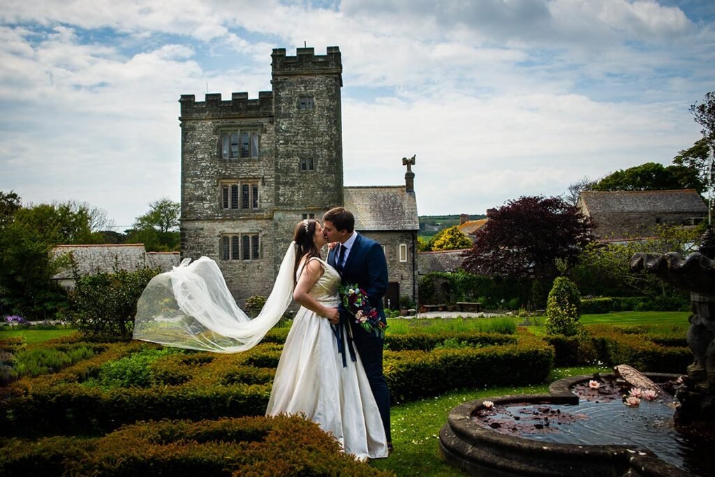 Bride and Groom kissing in the gardens at Pengersick Castle