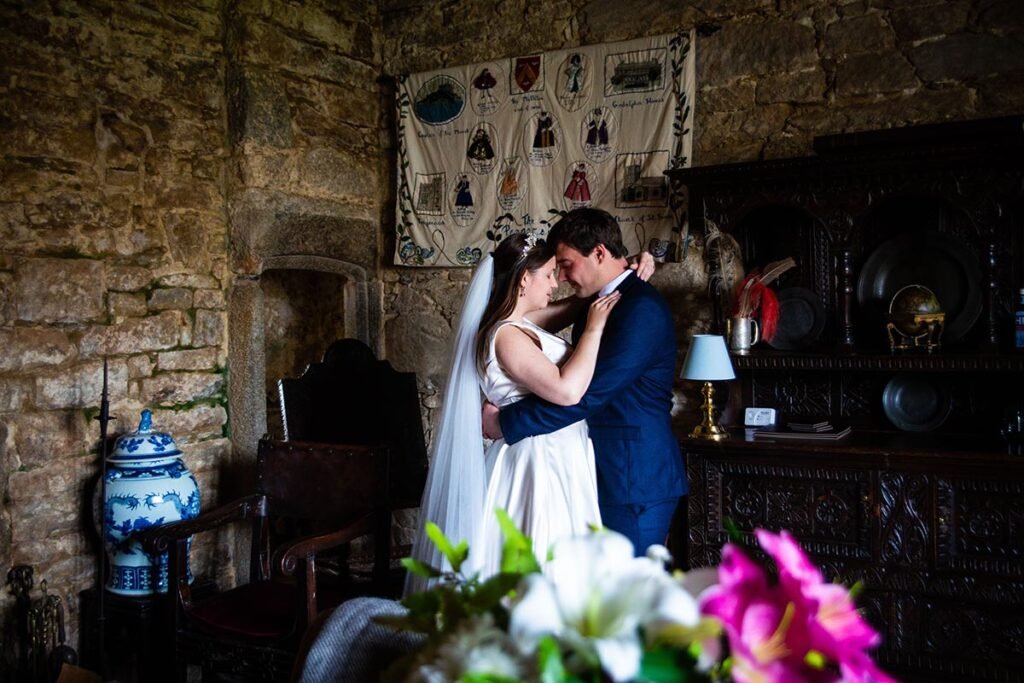 Bride and Groom embrace in the castle at Pengersick Castle