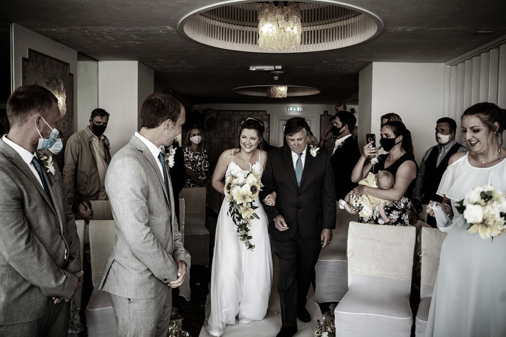 Bride acoming down the aisle at Hannafore Point Hotel in Looe Cornwall sepia