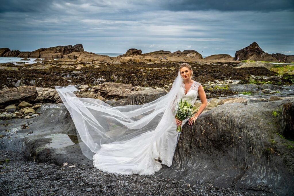 Bride on the rocks by the sea at Tunnels beaches Ilfracombe Devon