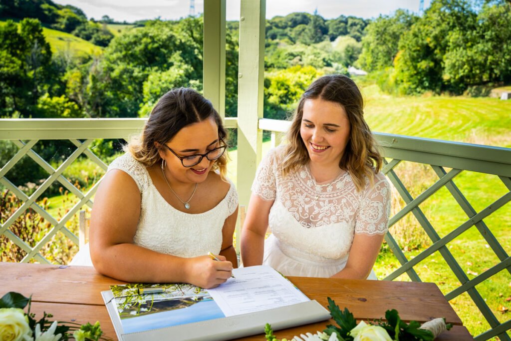 bride and bride signing the register at Pengenna Manor Cornwall