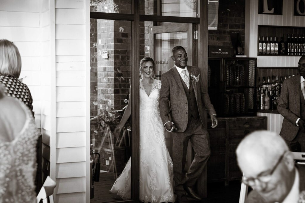 Bride and Groom entering the reception at Tunnels beaches Ilfracombe Devon sepia