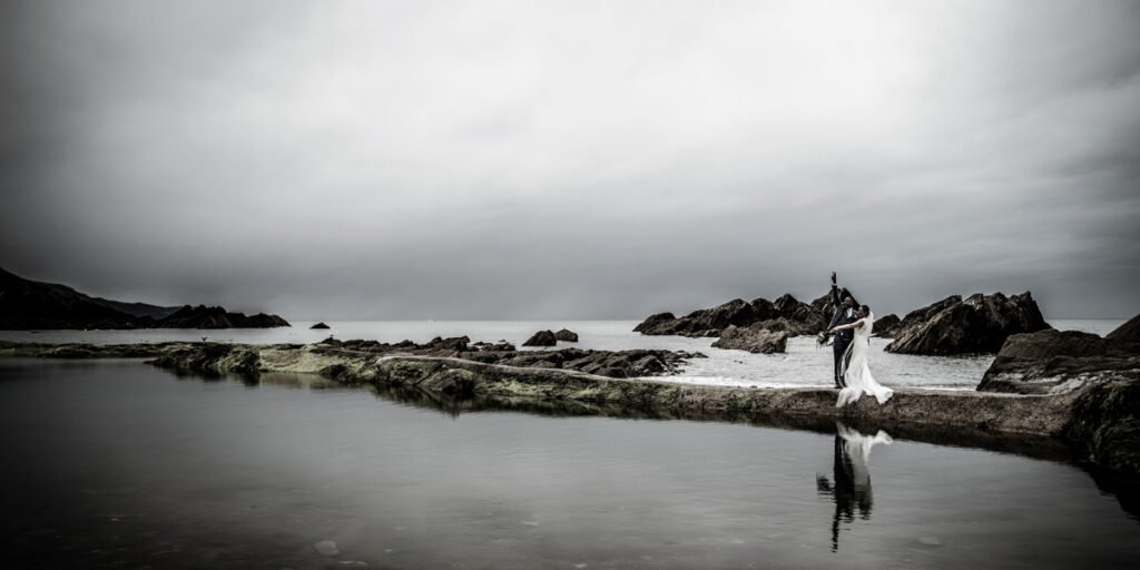 Bride and Groom by the sea pool at Tunnels beaches Ilfracombe Devon modern antique