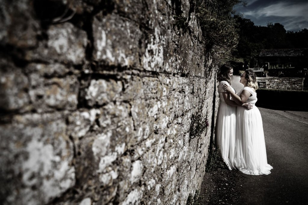 bride and bride in the grounds at Pengenna Manor Cornwall sepia