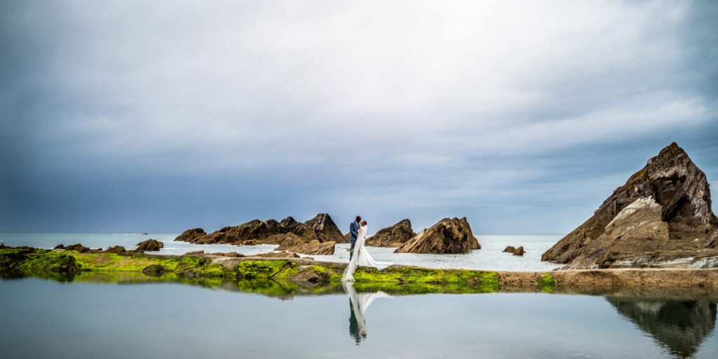 Bride and groom by the sea pool at Tunnels beaches Ilfracombe Devon