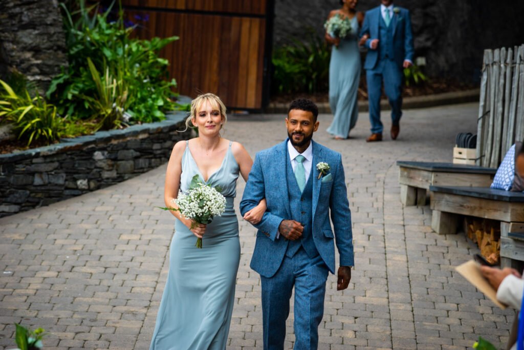 Bridesmaid and groomsman arriving for the wedding ceremony at Tunnels beaches Ilfracombe Devon