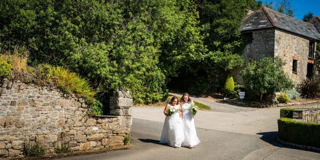 bride and bride arriving at the outdoor ceremony at Pengenna Manor Cornwall