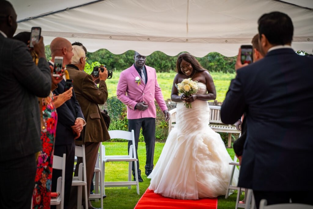 bride coming down the aisle at glebe farm cottages devon wedding venue