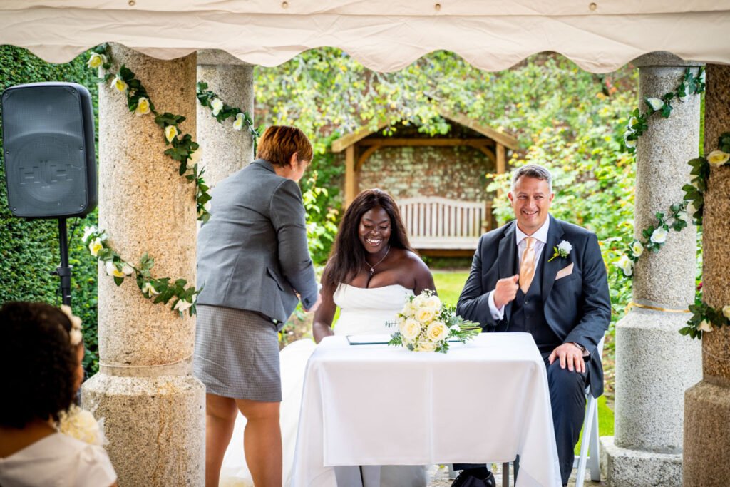 bride and groom signing the register at glebe farm cottages devon wedding venue