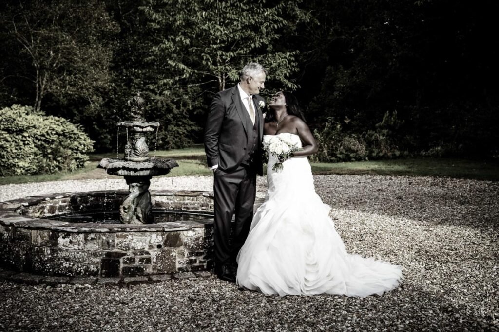 bride and groom by the fountain at glebe farm cottages devon wedding venue