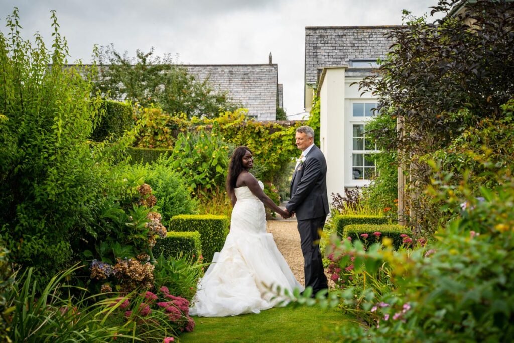 bride and groom in the gardens at glebe farm cottages devon wedding venue