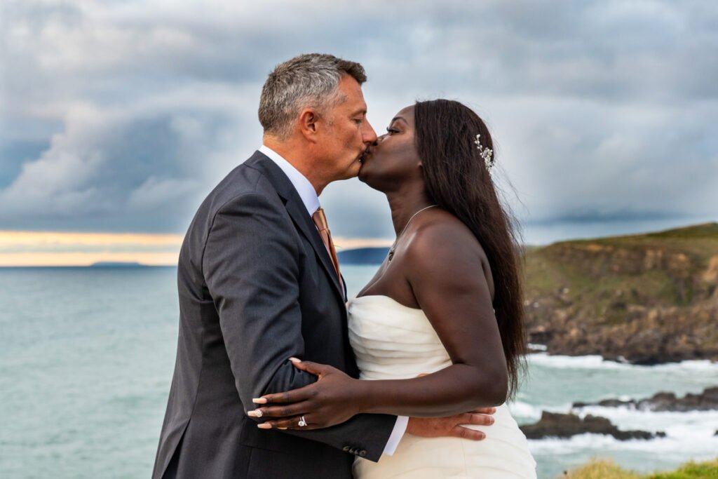 bride and groom kissing sunset shot at Widemouth bay Cornwall