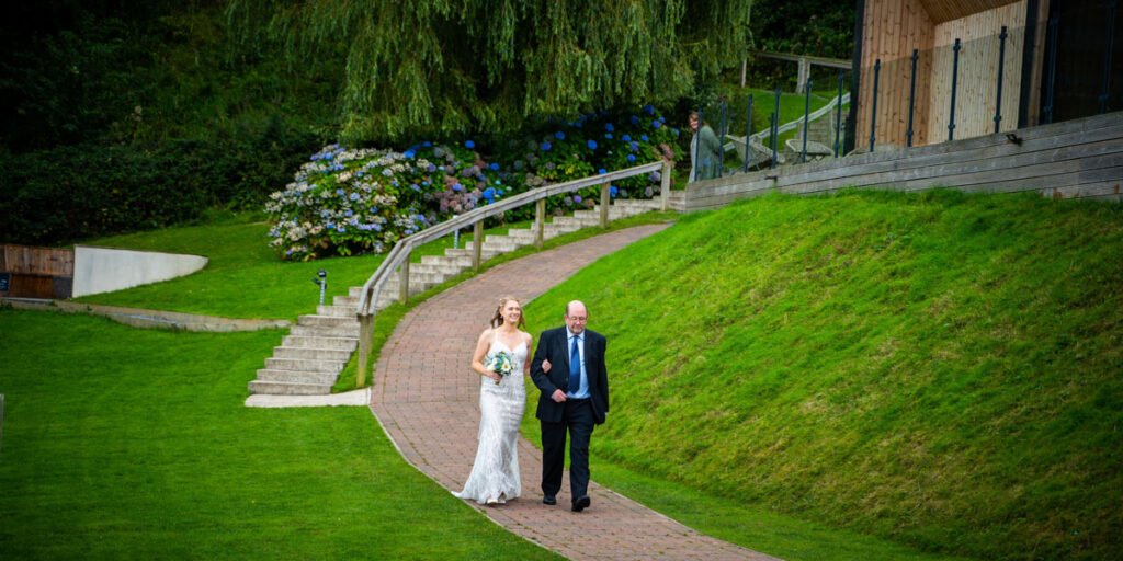 bride coming down the aisle at devon wedding venue The Sandy cove hotel