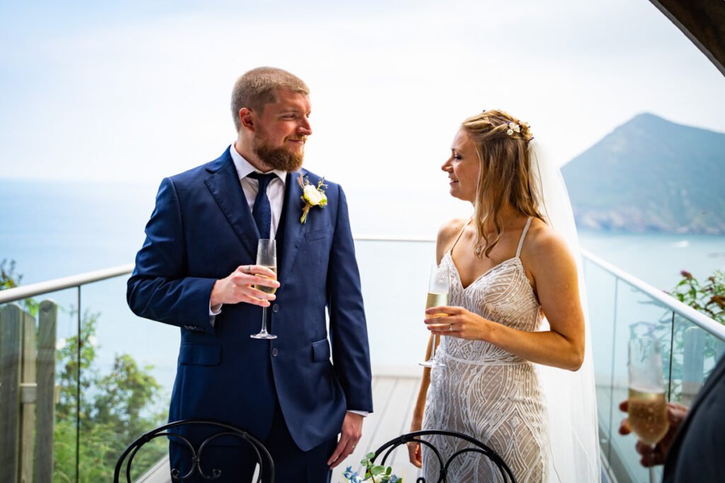 bride and groom having a glass of champagne seaview