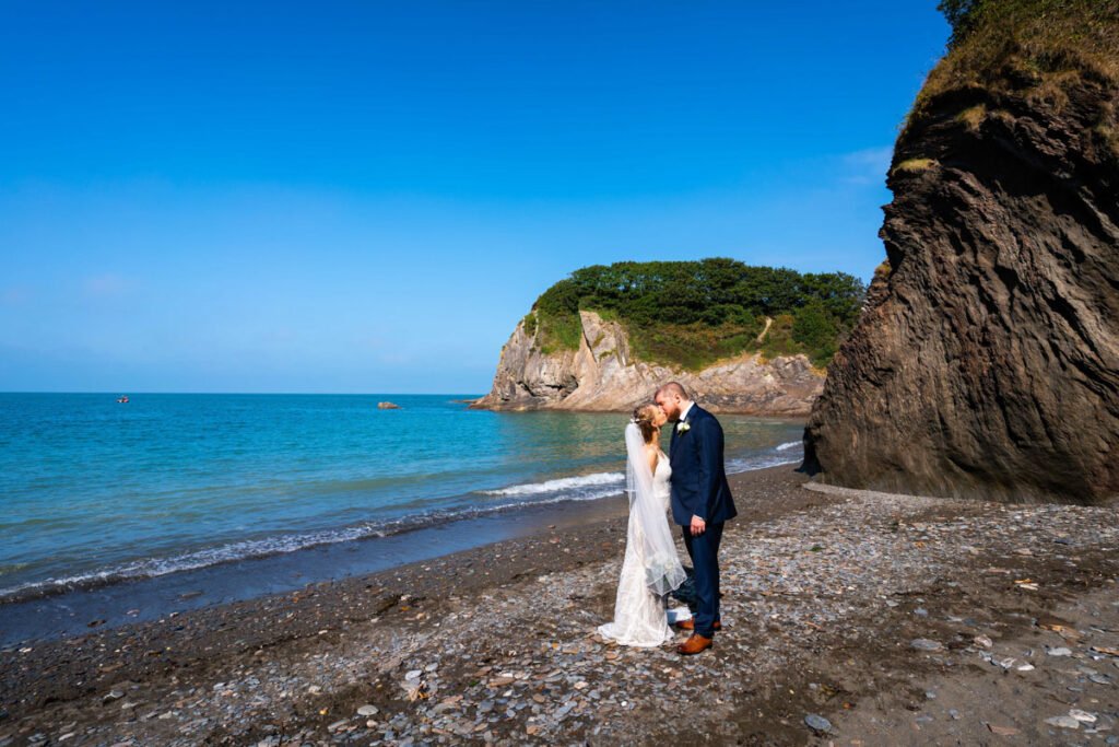 bride and groom kissing on the beach at devon wedding venue The Sandy cove hotel