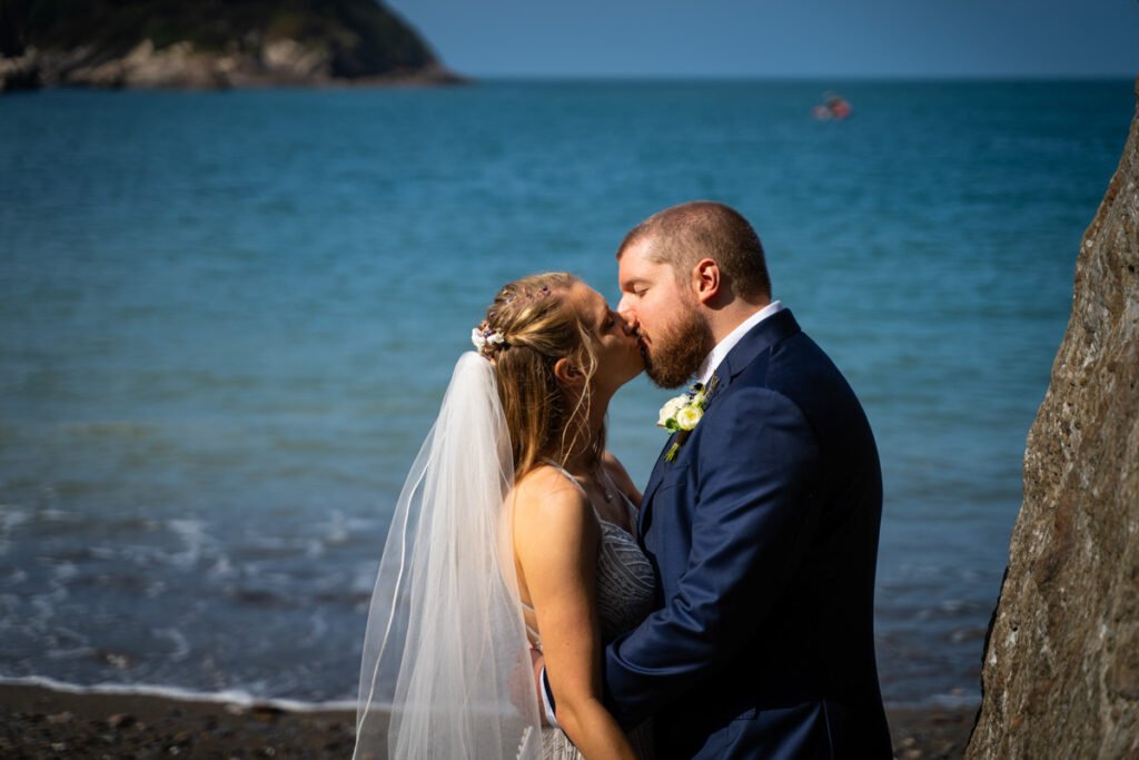bride and groom kissing on the beach at devon wedding venue The Sandy cove hotel