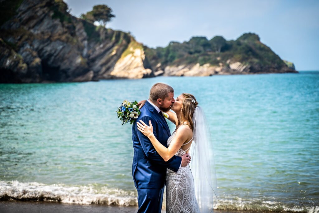 bride and groom kissing on the beach at devon wedding venue The Sandy cove hotel