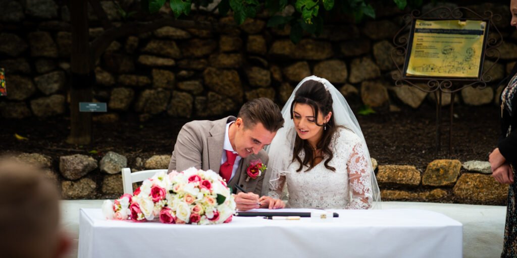Bride and groom signing the wedding register at the Eden Project Cornwall
