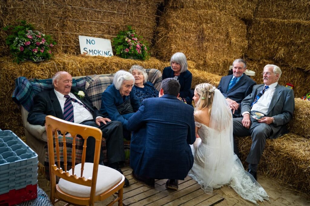 bride and groom talking to elderly guests in a barn