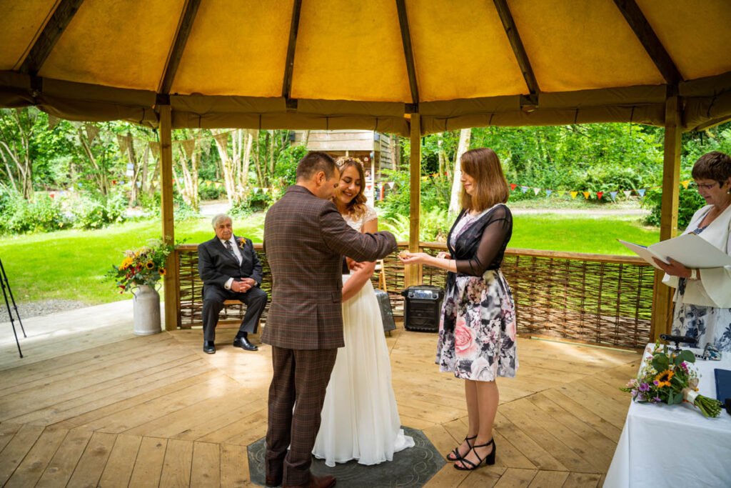 bride and groom exchanging rings at cornish tipis in cornwall