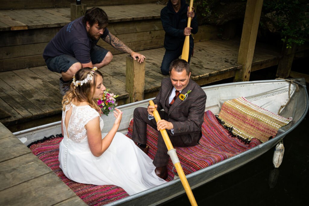 bride and groom rowing boat on the lake at cornish tipis in cornwall