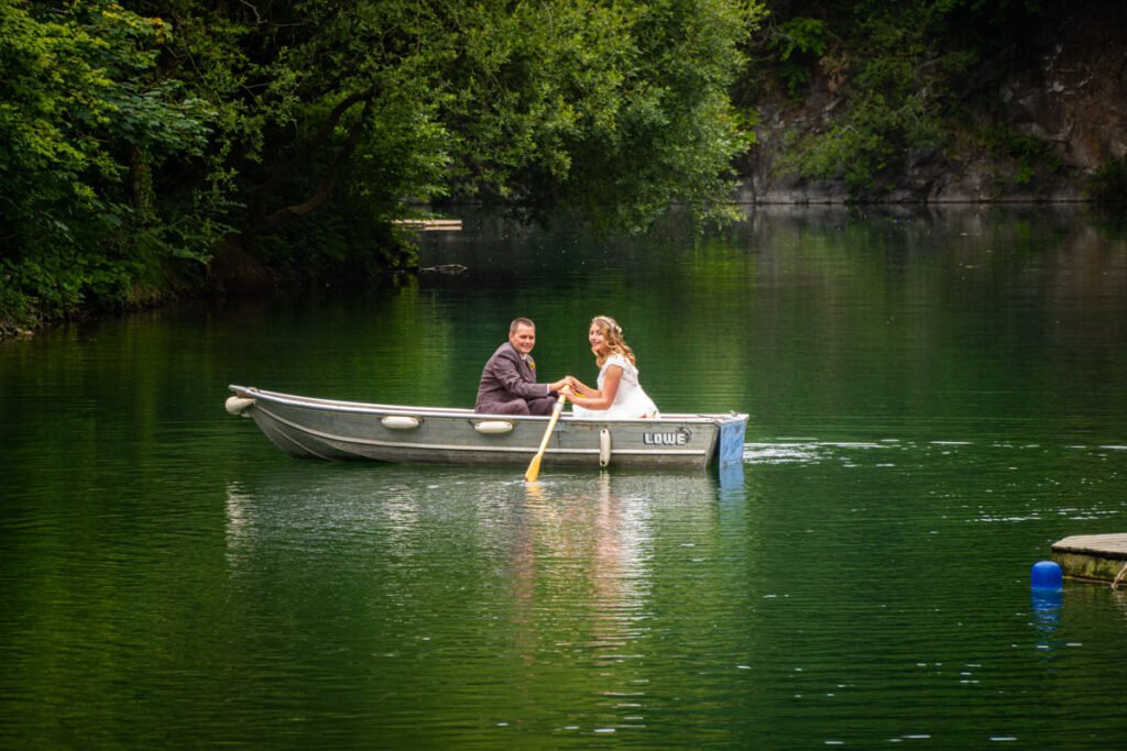 bride and groom rowing boat on the lake at cornish tipis in cornwall