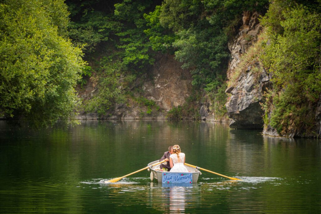 bride and groom rowing boat on the lake at cornish tipis in cornwall