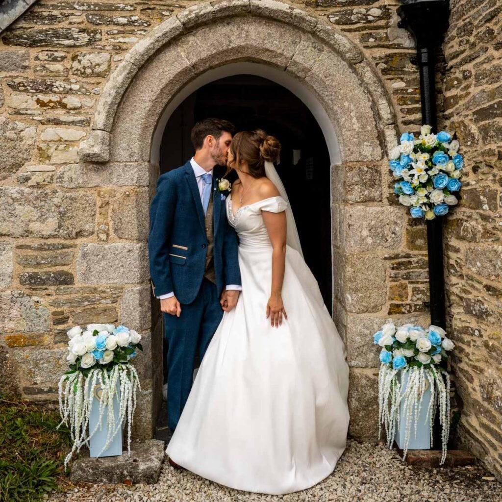 Bride and groom kissing in the church doorway