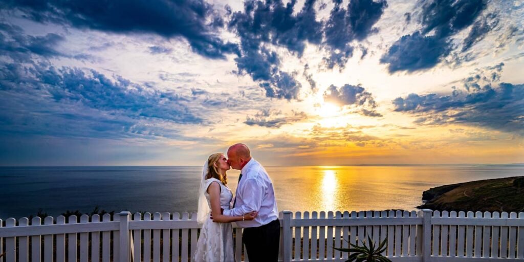 Bride and groom sunset kiss at the beach