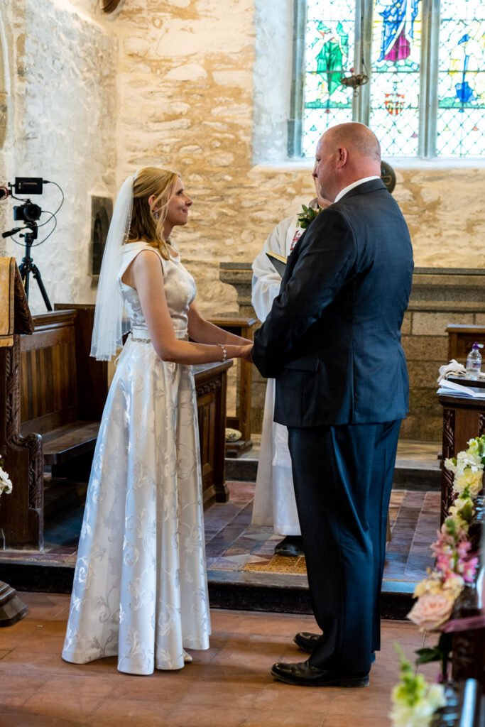Bride and groom saying their vows at a church in cornwall