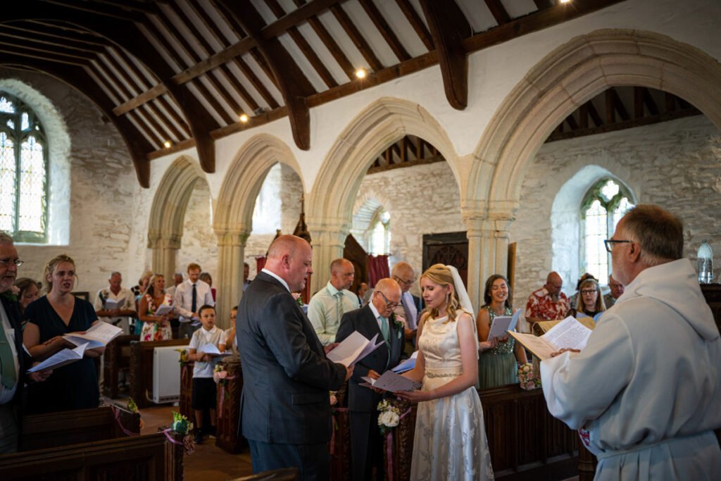 bride and groom singing during the wedding ceremony in cornwall