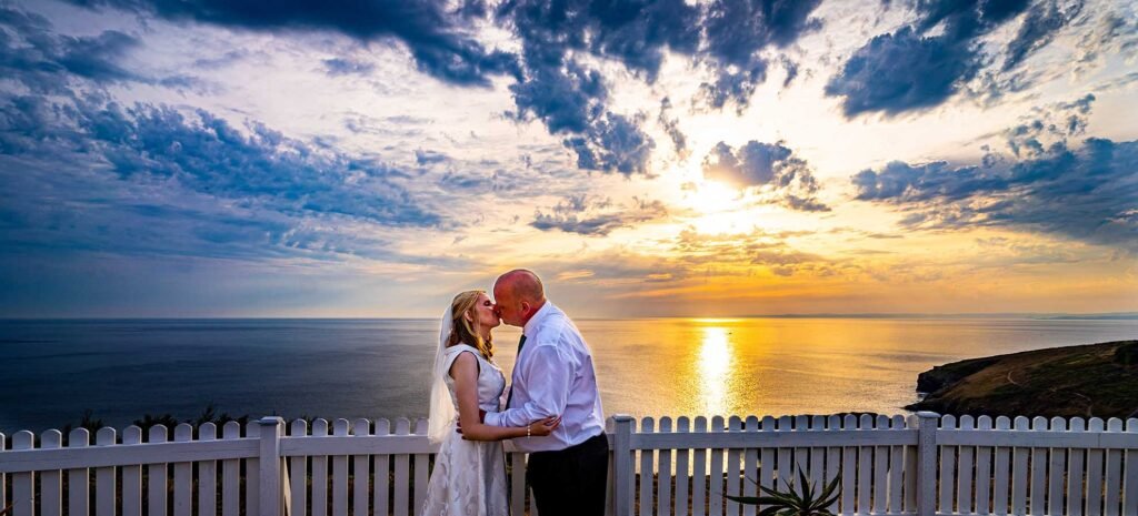 Bride and groom kissing sunset shot at the Polurrian hotel cornwall