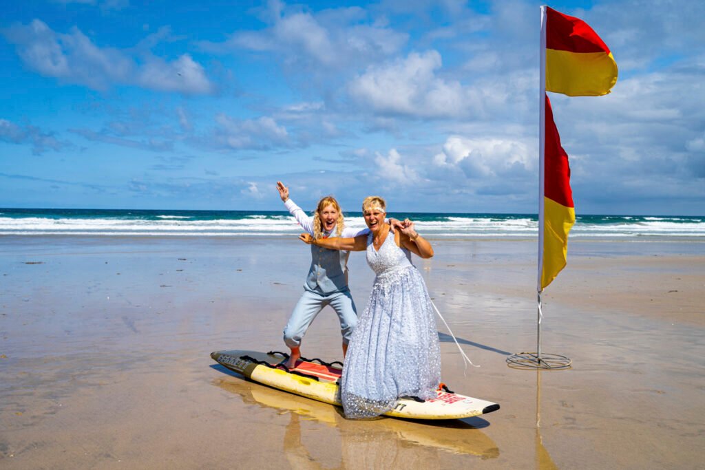 newquay same sex wedding bride and bride on a surfboard