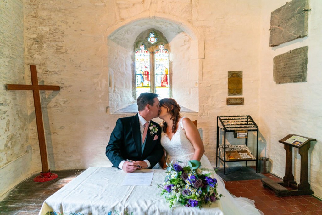 bride and groom signing and kissing