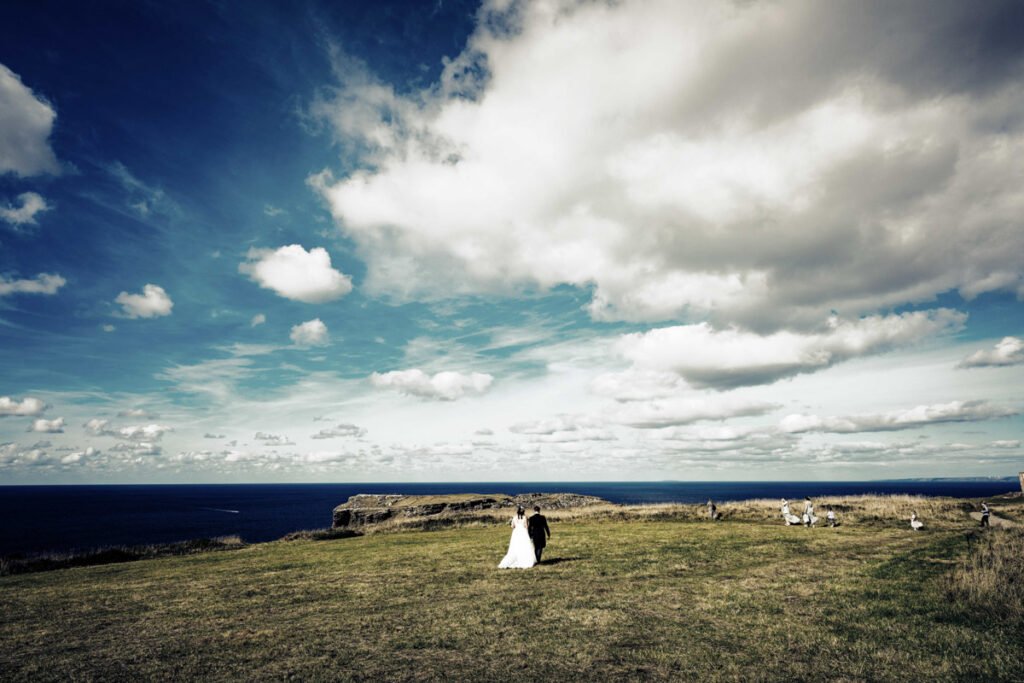 Bride and groom on the cliff overlooking tintagel island