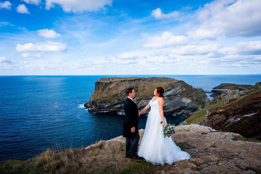 Bride and groom on the cliff overlooking tintagel island