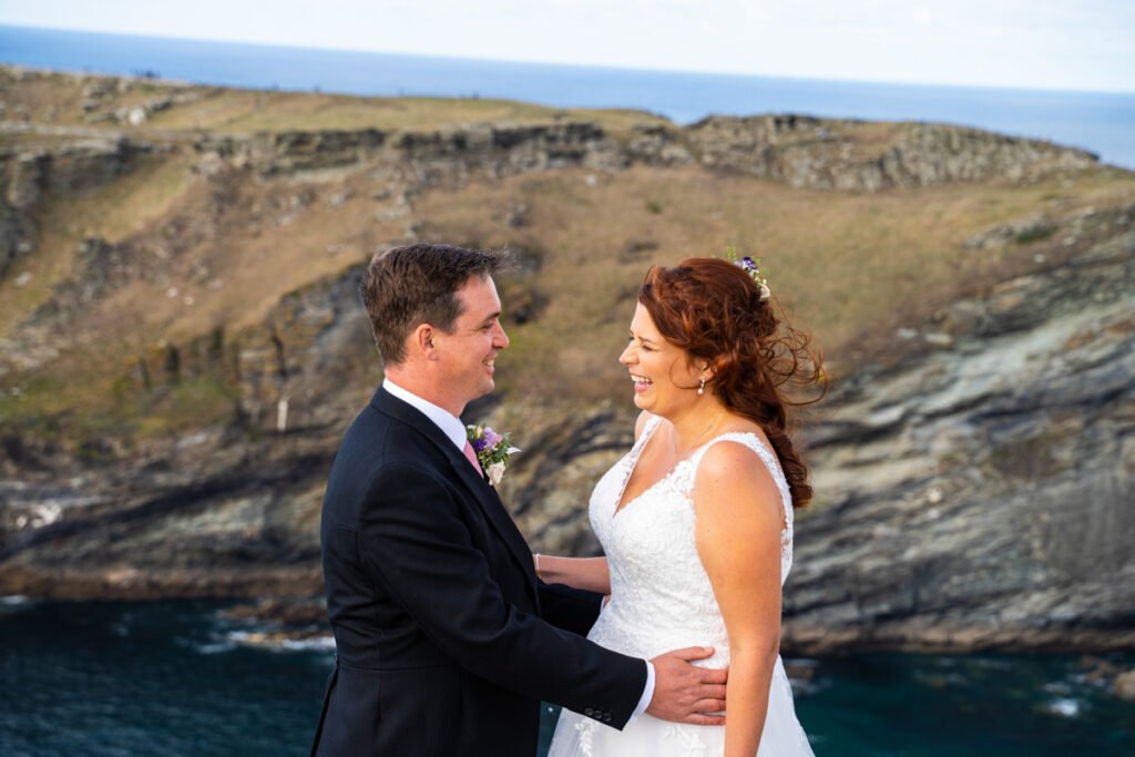 Bride and groom on the cliff overlooking tintagel island