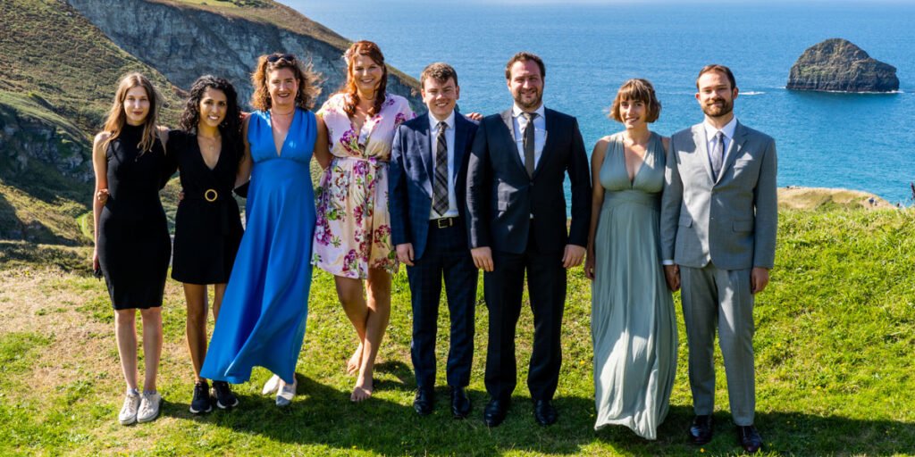 wedding group photo overlooking the sea in cornwall